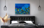 Load image into Gallery viewer, Predominantly blue floral painting shown  in a bedroom setting above e a charcoal grey headboard and linens.
