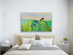 Load image into Gallery viewer, Purple irises with teal water and pretty sky displayed above a bed with neutral furnishings
