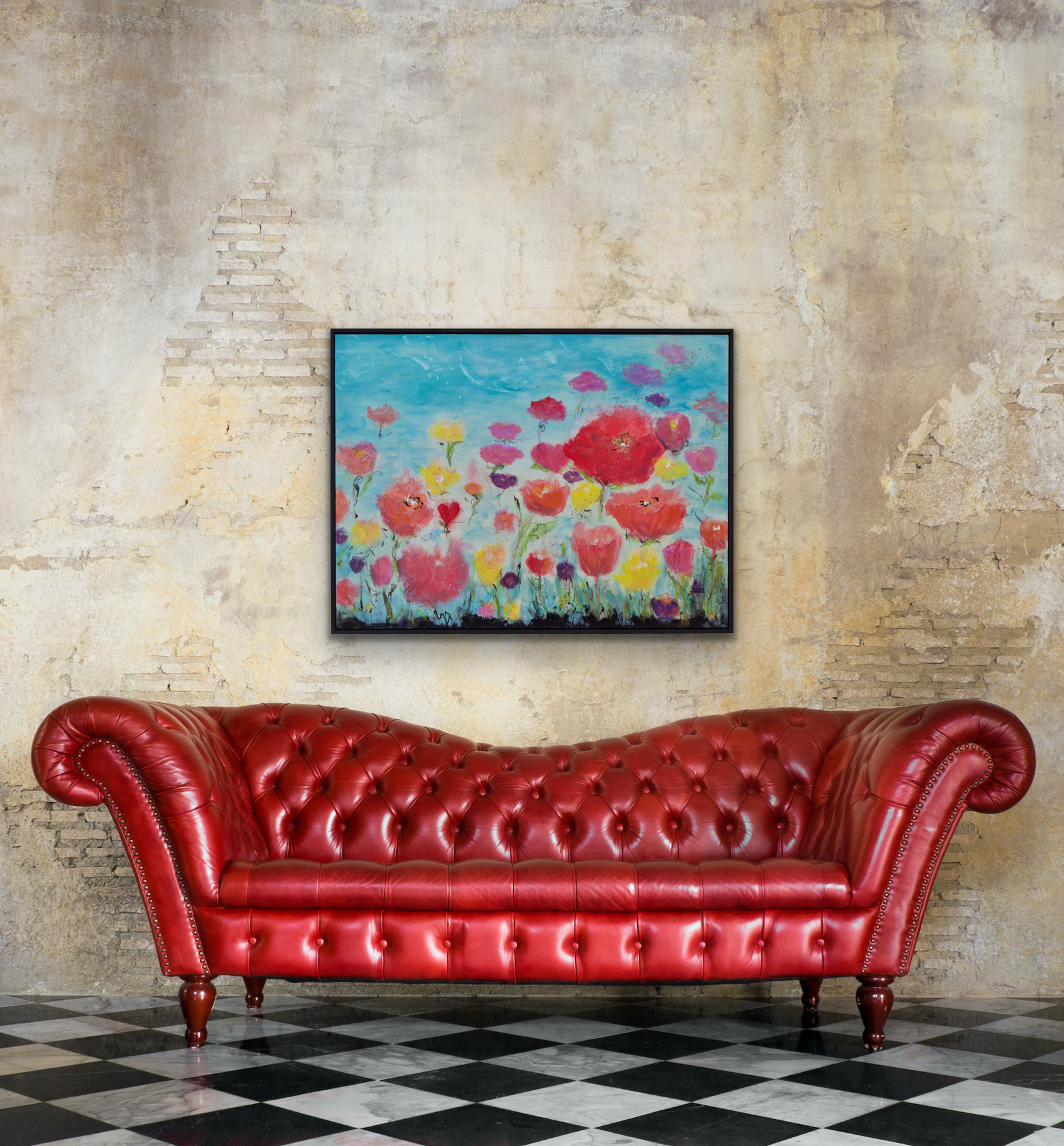 Vibrant art shown above a red leather sofa against a natural brick wall