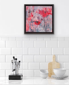 Displayed on a white wall in a kitchen setting. This original painting exudes excitement with its red abstract flowers on a grey and coral background and invites the viewer to be positive no matter the weather. 