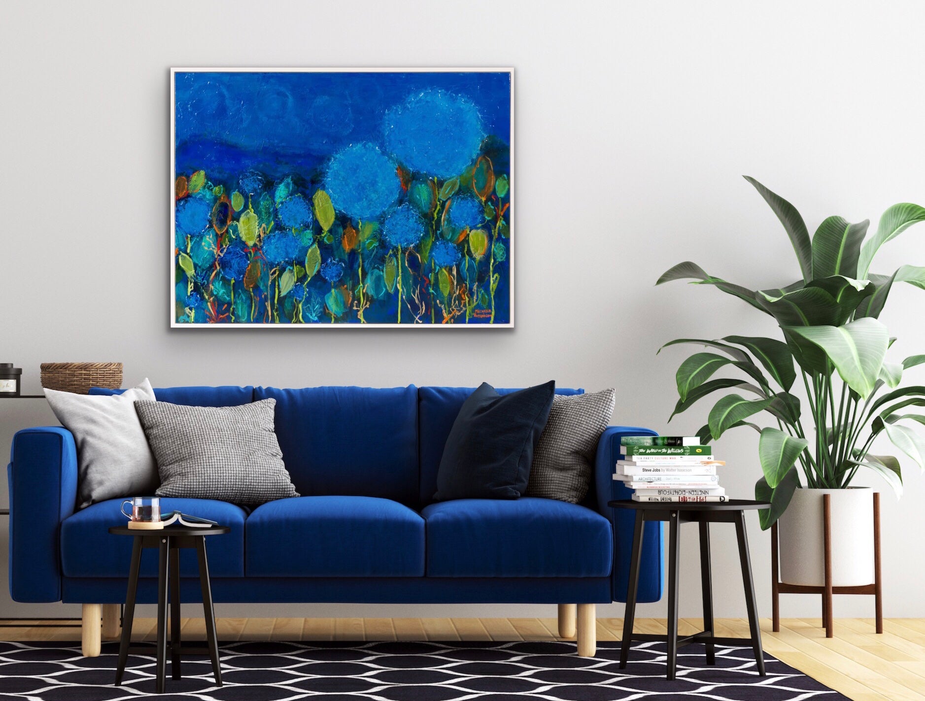 Predominantly blue floral painting shown above a blue velvet sofa.