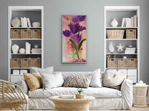 This strong purple, coral, and green floral vertical painting is displayed in a neutral living room setting to inject a pop of colour into the space.